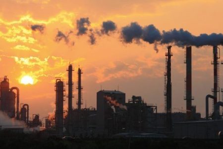 Air pollution smoke from pipes and factory with sunset background